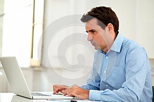 Handsome 30s businessman working with his laptop