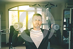 Handsome 40s caucasian man lifting weights at gym