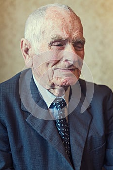 Handsome 80 plus year old senior man posing for a portrait in his living room
