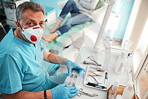 Handsome adult European man in uniform working at the doctor desk in the medical center