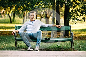 Handsome adult man sitting on bench