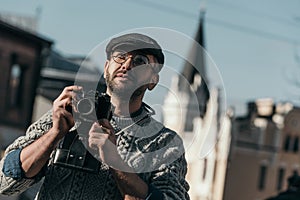 handsome adult man with vintage film camera in old