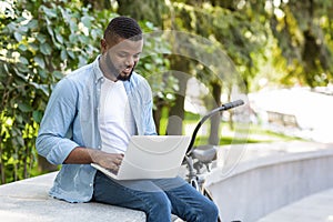 Handsome Aferican American Freelancer Guy Working On Laptop In Park