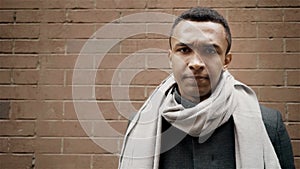 Handsome African American adult man says no shaking his head. Brick wall on background.