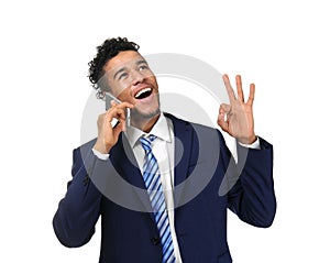 Handsome African-American businessman talking by mobile phone on white background