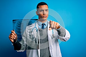 Handsome african american doctor man wearing stethoscope holding chest xray pointing with finger to the camera and to you, hand