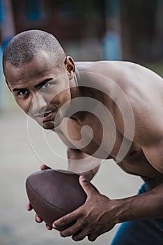 Handsome african american male football player with ball