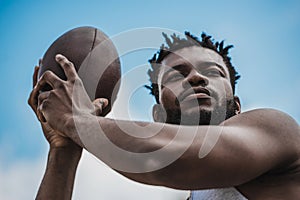 Handsome african american male football player with ball