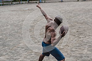 Handsome african american male football player with ball on court