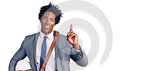 Handsome african american man with afro hair holding architect hardhat surprised with an idea or question pointing finger with