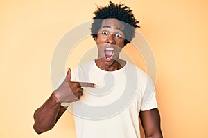 Handsome african american man with afro hair pointing with fingers to himself celebrating crazy and amazed for success with open