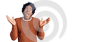 Handsome african american man with afro hair wearing casual clothes celebrating mad and crazy for success with arms raised and