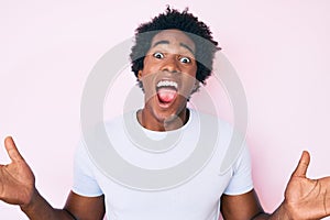 Handsome african american man with afro hair wearing casual clothes celebrating victory with happy smile and winner expression