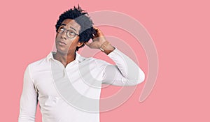 Handsome african american man with afro hair wearing casual clothes and glasses confuse and wondering about question