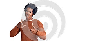 Handsome african american man with afro hair wearing casual clothes pointing fingers to camera with happy and funny face