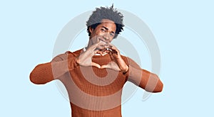 Handsome african american man with afro hair wearing casual clothes smiling in love doing heart symbol shape with hands