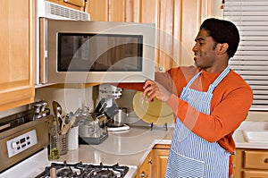 Handsome African-American man cooks in kitchen