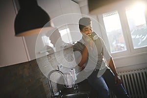 Handsome african american man drinking coffee in kitchen