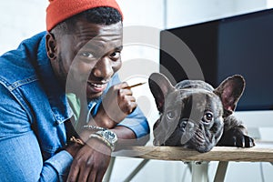 Handsome african american man with Frenchie dog