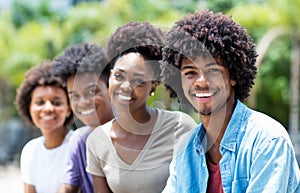 Handsome african american man with group of young adults in line photo