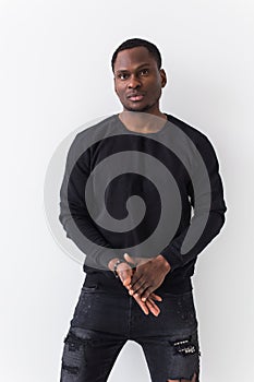 Handsome African American man posing in black sweatshirt on a white background. Youth street fashion photo with afro