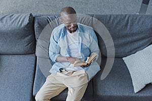 Handsome african american man reading book