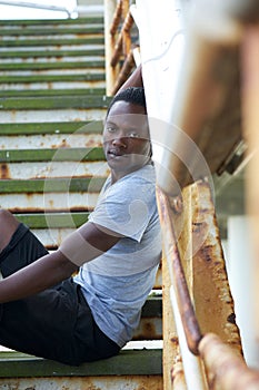 Handsome african american man sitting on stairs outdoors