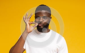 Handsome african american man zipping his mouth with gesture