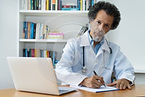 Handsome african american senior doctor at work