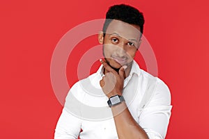 Handsome african american young man thinking over red background.