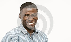 Handsome African guy with white-toothed smile looking at camera, dark-skinned well-dressed young man cut out on white