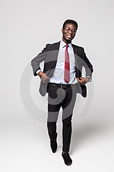 Handsome African man in a suit move isolated on grey background