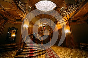 Handsome african man waiting for his girlfriend on the vintage stairs. Luxurious theatre interior background