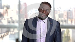 Handsome afro-american businessman checking time on watch.