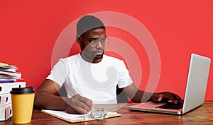 Handsome afro american guy is thinking at work, work on laptop