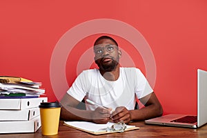 Handsome afro american guy is thinking at work, work on laptop