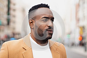 Handsome afro-american man biting his lip and looking aside in Gran via, Madrid photo