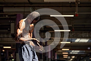 Handsome afro American sportman standing on the street while taking break after training. Black male having rest after