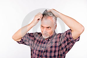 Handsome aged man combing hair