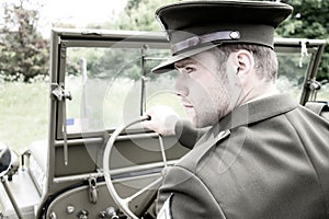 Handsome American WWII GI Army officer in uniform riding Willy Jeep