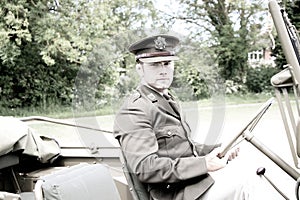 Handsome American WWII GI Army officer in uniform riding Willy Jeep