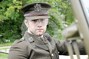 Handsome American WWII GI Army officer in uniform riding Willy Jeep