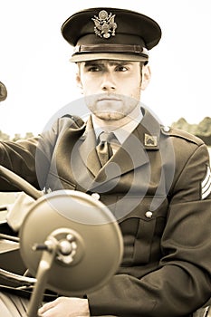 Handsome American WWII GI Army officer in uniform riding Willy Jeep