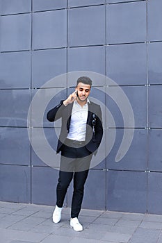 Handsome arabic man talks on smart phone in business center