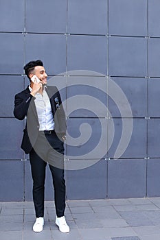 Handsome arabic man talks on smart phone in business center