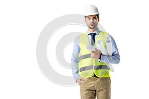 Handsome architect in reflective vest and helmet holding blueprints