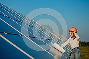 Handsome Architect Woman Examining a Draft Map or Blueprint Project Plan, Worker Activity Looking Out in Photovoltaic Cell Farm or