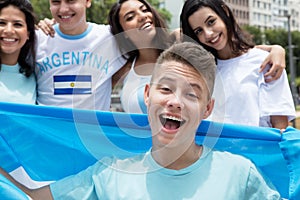 Handsome argentinian sports fan with other supporters from Argentina