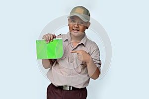 handsome asian boy with scout uniform pointing a book.