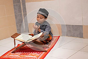 Handsome Asian boys are praying and studying al-qur`an